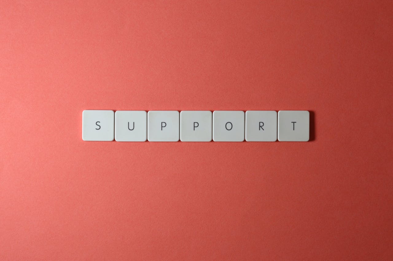 Close-up of the word 'support' spelled with keyboard keys on a red background.